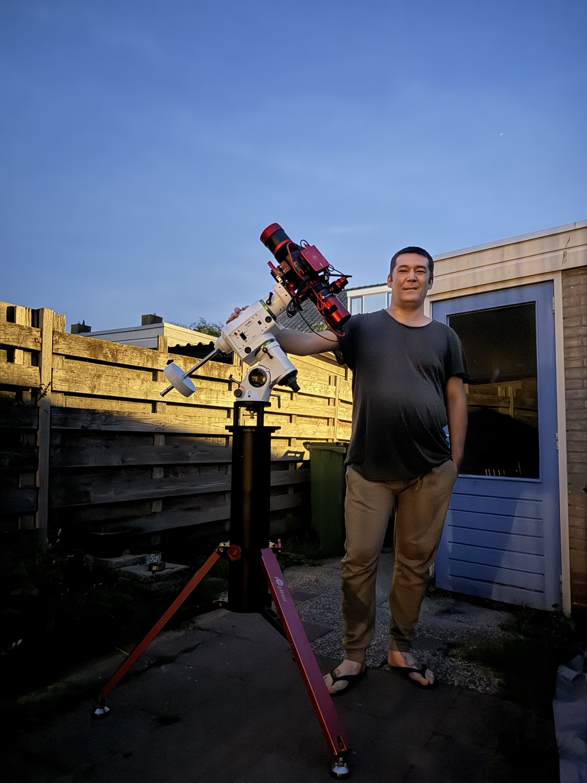 Islam beside his telescope in the garden