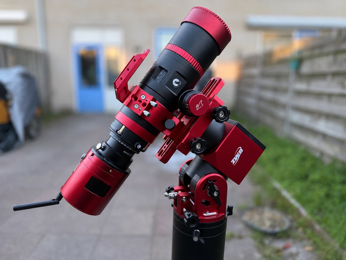 Close-up of a red and black astrophotography telescope and camera